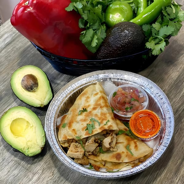 La Fonda St. chicken quesadilla with salsa, hot sauce, and fresh avocados, peppers, and cilantro.